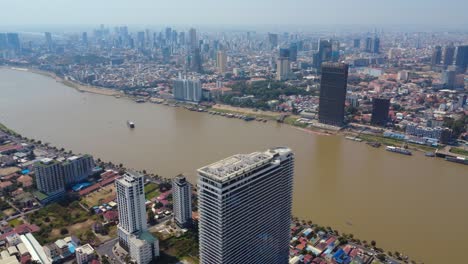 phnom penh mekong riverfront buildings and development, urban populated city under hazy sky due to air pollution, drone shot