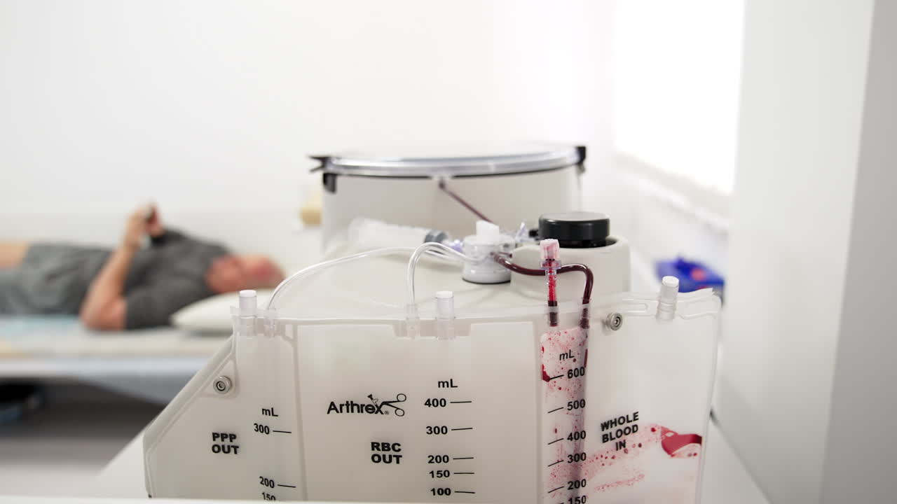 Advanced equipment for plasma preparation is working in the hospital room. Close up. Man is lying on the couch at blurred backdrop.