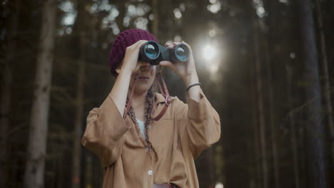 female explorer with binoculars in forest