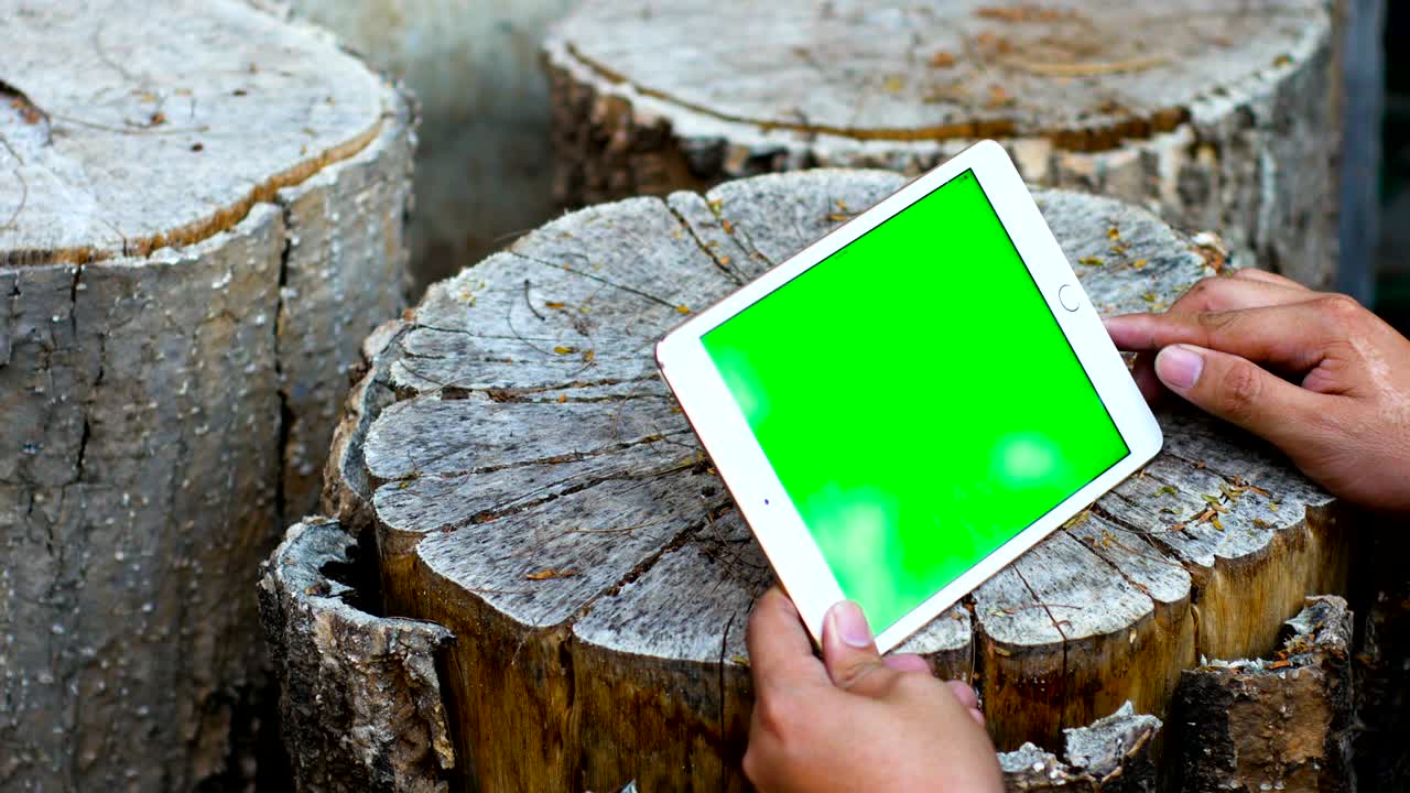 녹색 화면 을 가진 테이블 에 디지털 태블릿 을 사용 하는 사람