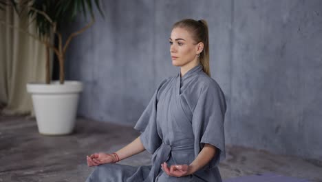 Elegant-woman-in-stylish-robe-sitting-in-lotus-pose