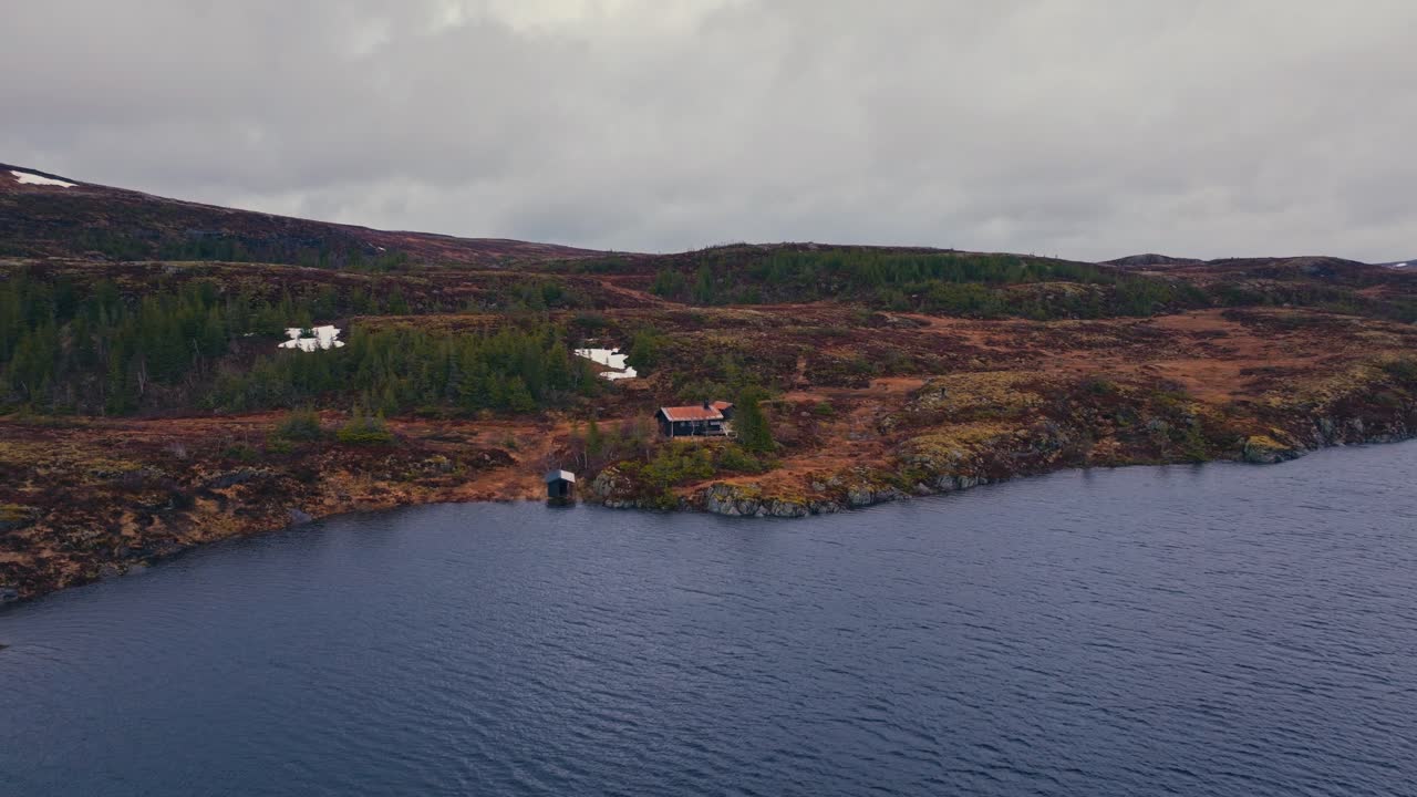 Cabin Isolated In The Mountain Near Lakeshore On A Cloudy Day. Aerial Shot