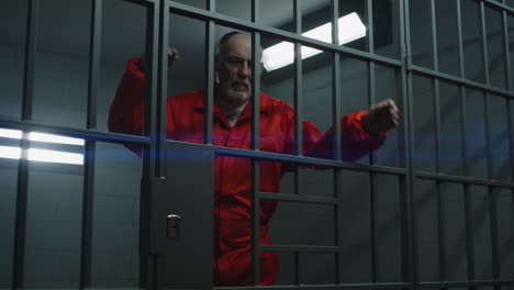 elderly prisoner leans on metal bars and looks at camera