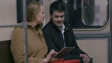 couple with tablet pc in public transport