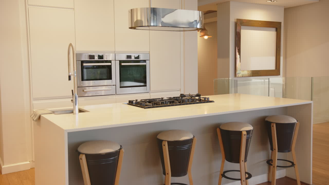 Modern kitchen with island, bar stools, and stainless steel appliances in home