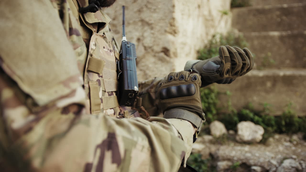 Hands Of A Soldier Putting On Gloves Before Battle