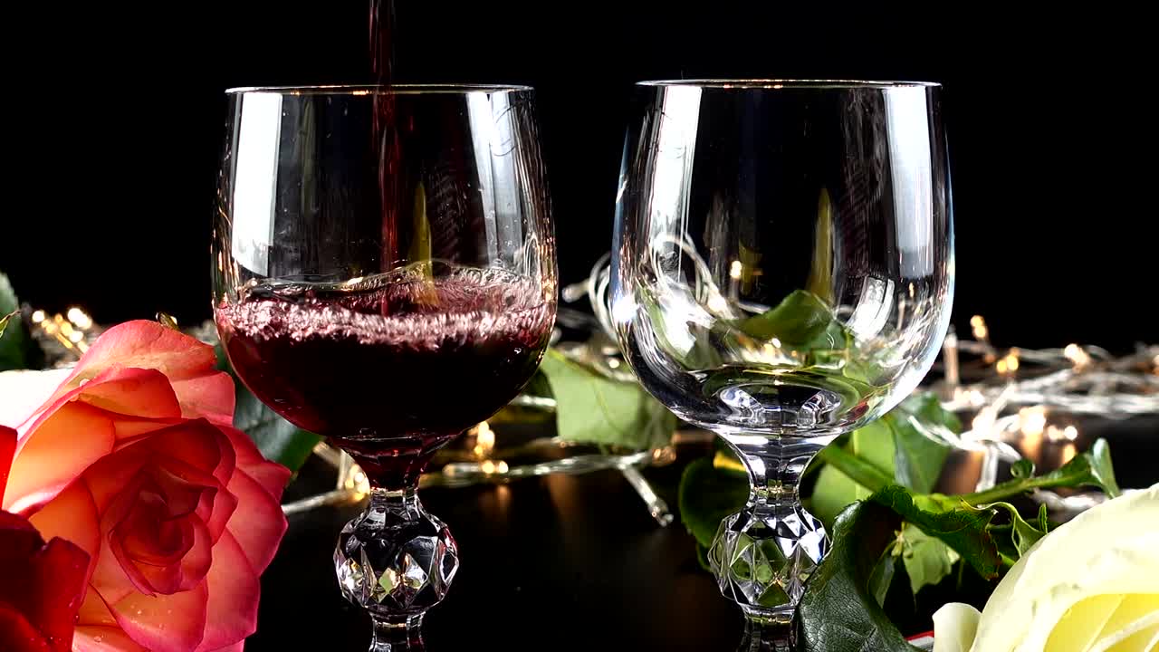 Taças de vinho e rosa contra o fundo de guirlandas brilhantes