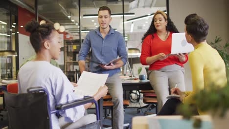 personas con discapacidad felices y diversas personas de negocios discutiendo el trabajo durante una reunión en la oficina