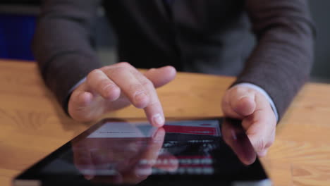 mãos do homem tocando a tela do tablet