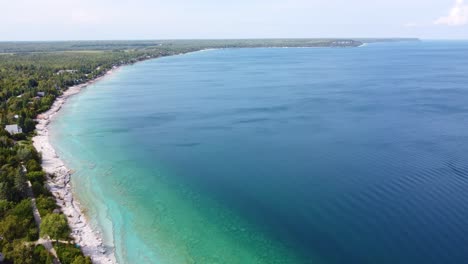 La-Hermosa-Costa-Rocosa-Blanca-Se-Erosiona-Suavemente-En-Capas-Hasta-Volverse-Verde-Y-Luego-Cae-Hacia-Un-Azul-Profundo.