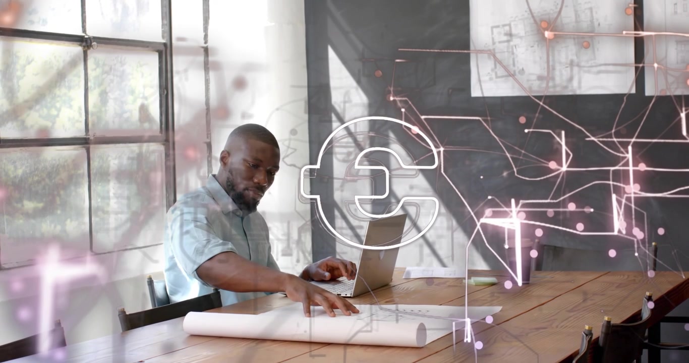 Designer typing on laptop and activating circuit lines with euro symbol over blueprints