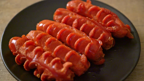 deep fried sausage skewer on black plate