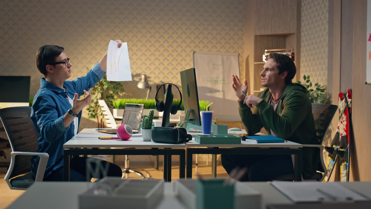Business coworkers discussing project together at office. Man crumpling paper