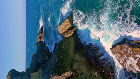 vertical aerial of waves crashing against rocky coastline in cabo frances viejo