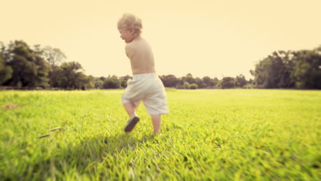 cute baby boy running in grass field