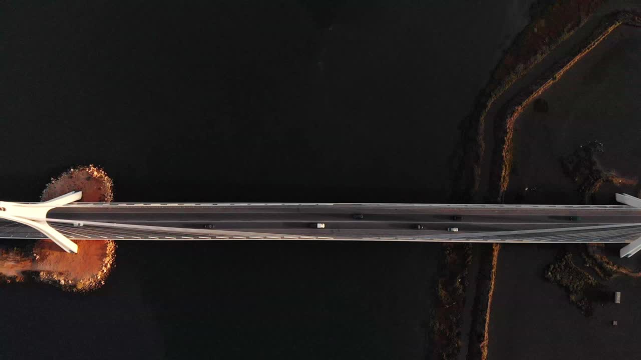 검은 강 위의 현대적인 다리에서 자동차 운전의 조감도