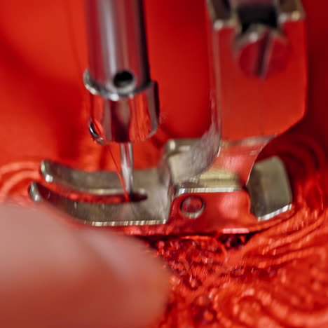 close-up needle of a sewing machine working on red fabric. sewing process at making a beautiful flower on a red cloth.