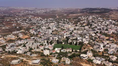 aerial view over palestinian town biddu with soccer field, near jerusalem