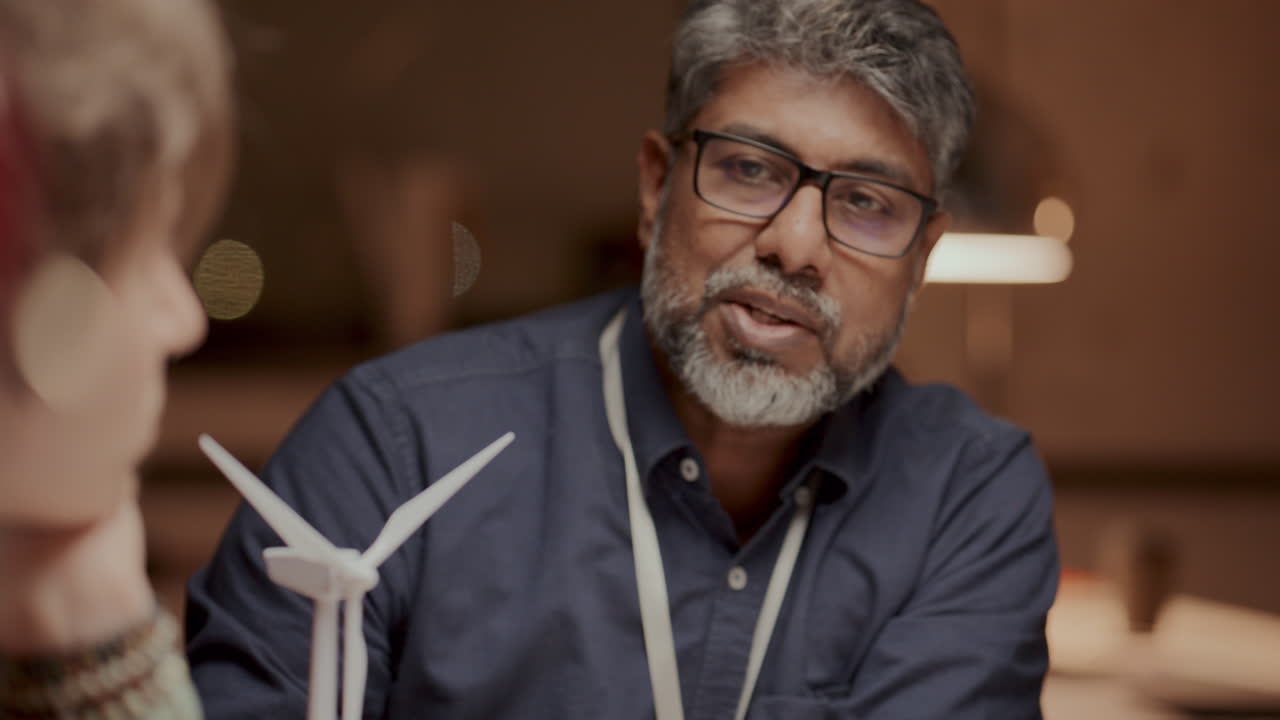 especialista sênior explicando conceitos de energia eólica a colegas