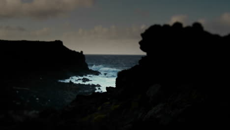 Pan-across-a-darkened-coastline-to-an-ocean-inlet