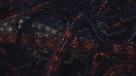 Big-Interstate-Freeway-Connection-with-Traffic-Jam-at-Night,-Aerial-Birds-Eye-Overhead-Drone-Perspective