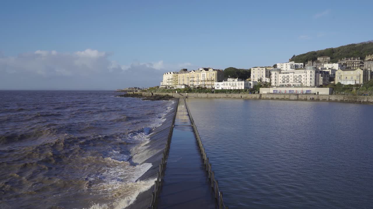 WESTON SUPER MARE, SOMERSET, ENGLAND, December 22, 2019: Waves crushing into artificial beach. Tourist footpath flooded.