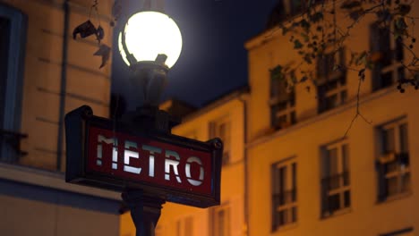 signo del metro de parís en la lámpara de la calle por la noche