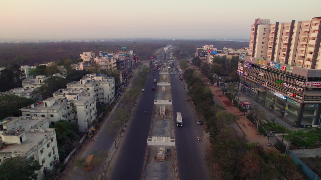 Under construction flyover with Jain Friends Square building and National highway 44 at suchitra circle, hyderabad, telangana, india. day time, push in, drone shot, 4k.
