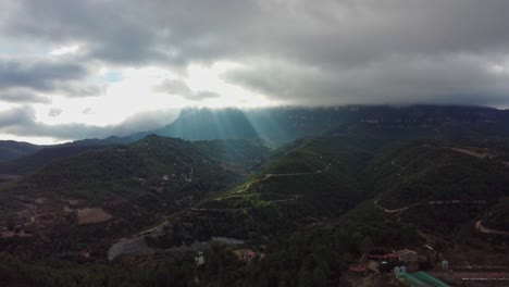 sunlight breaking through clouds over montserrat and marganell mountains