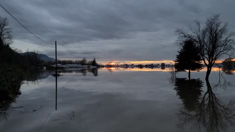 motion sideways of flooding in abbotsford during sunset with reflection on water surface