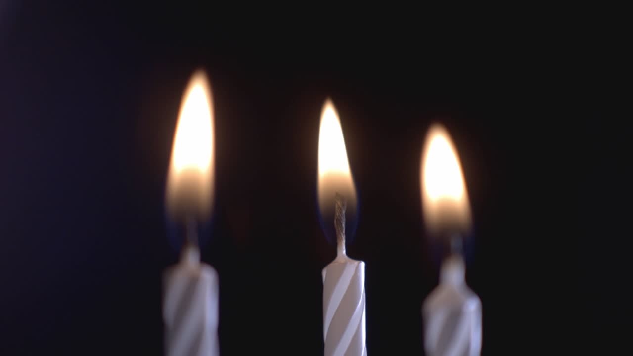 Tre luci di candela che brillano sullo sfondo scuro. - primo piano
