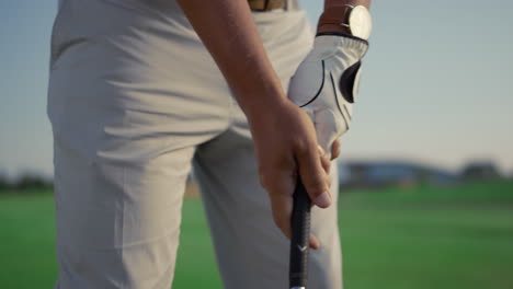 player hold golf putter club on golfing game. man play sport activity on course.