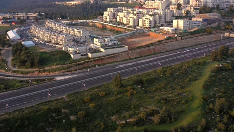 aerial view of modern residential buildings, highway, and forest