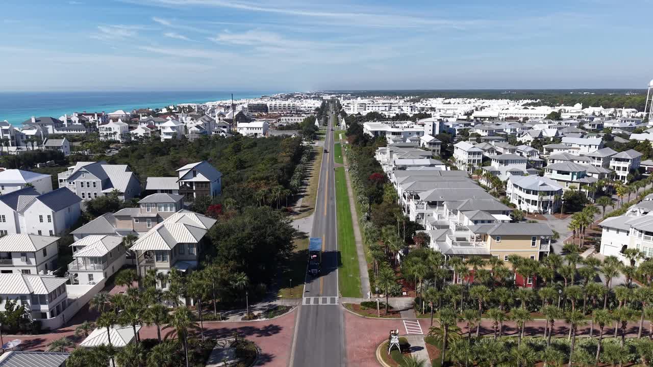 Forward drone fly over long coastal East County Highway 30A road with white houses leading toward near the Gulf at Alys Beach, Florida, USA