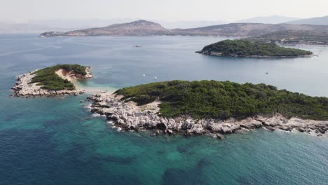 Orbiting-view-of-Islets-of-Ksamil,-Scenic-coastline-in-Background,-Touristic-Summer-destination,-Albania