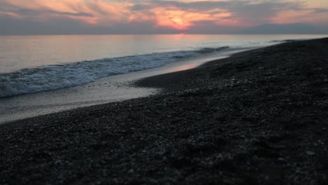 Ruhiger-Kiesstrand-In-Zeitlupe-Bei-Sonnenuntergang-Mit-Ruhigen-Wellen-Bei-Ebbe