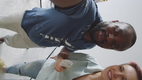 una pareja pintando su casa.
