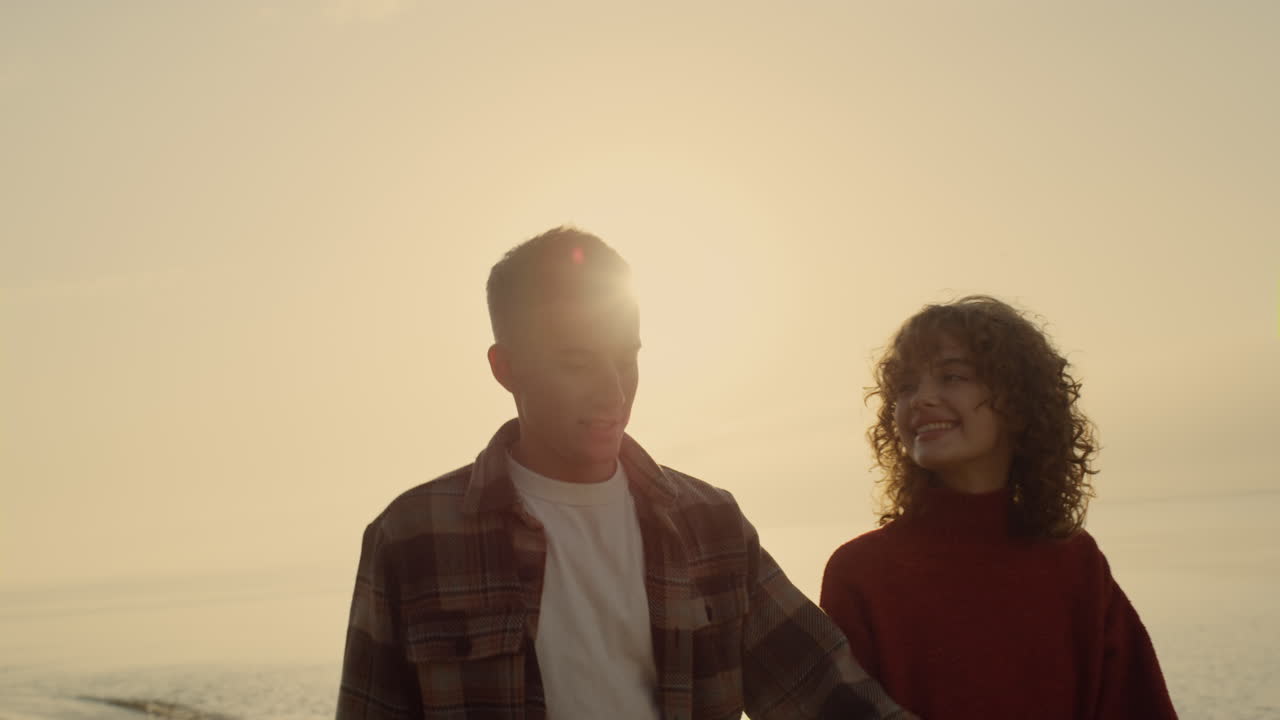 pareja abrazándose en la playa al amanecer. mujer y hombre besándose en la orilla del océano