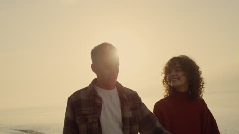 Couple-embracing-on-beach-at-sunrise.-Woman-and-man-kissing-on-ocean-shore