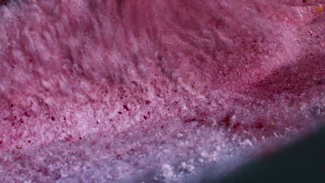 red and pink powder being shot and lifted up into the air on a trampoline in slow motion by bursting into a cloud of chalky powder