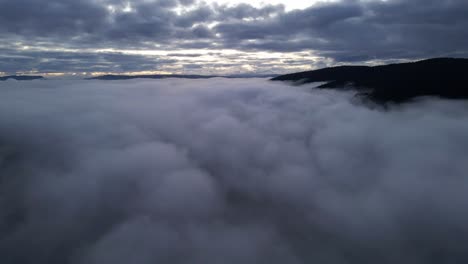 aerial slow push in shot above the clouds with mountain tops in chile