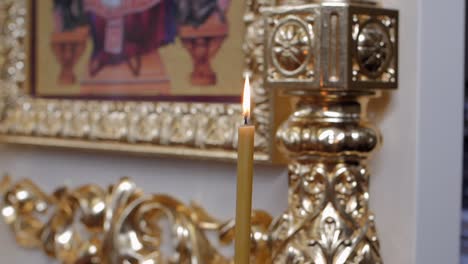 handheld parallax shot of a yellow candle with a softly blurred background