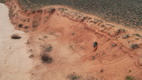 Aerial-View-of-ATV-Four-Wheeler-Vehicle-Moving-on-Desert-Track-and-Steep-Hill,-Drone-Shot-60fps