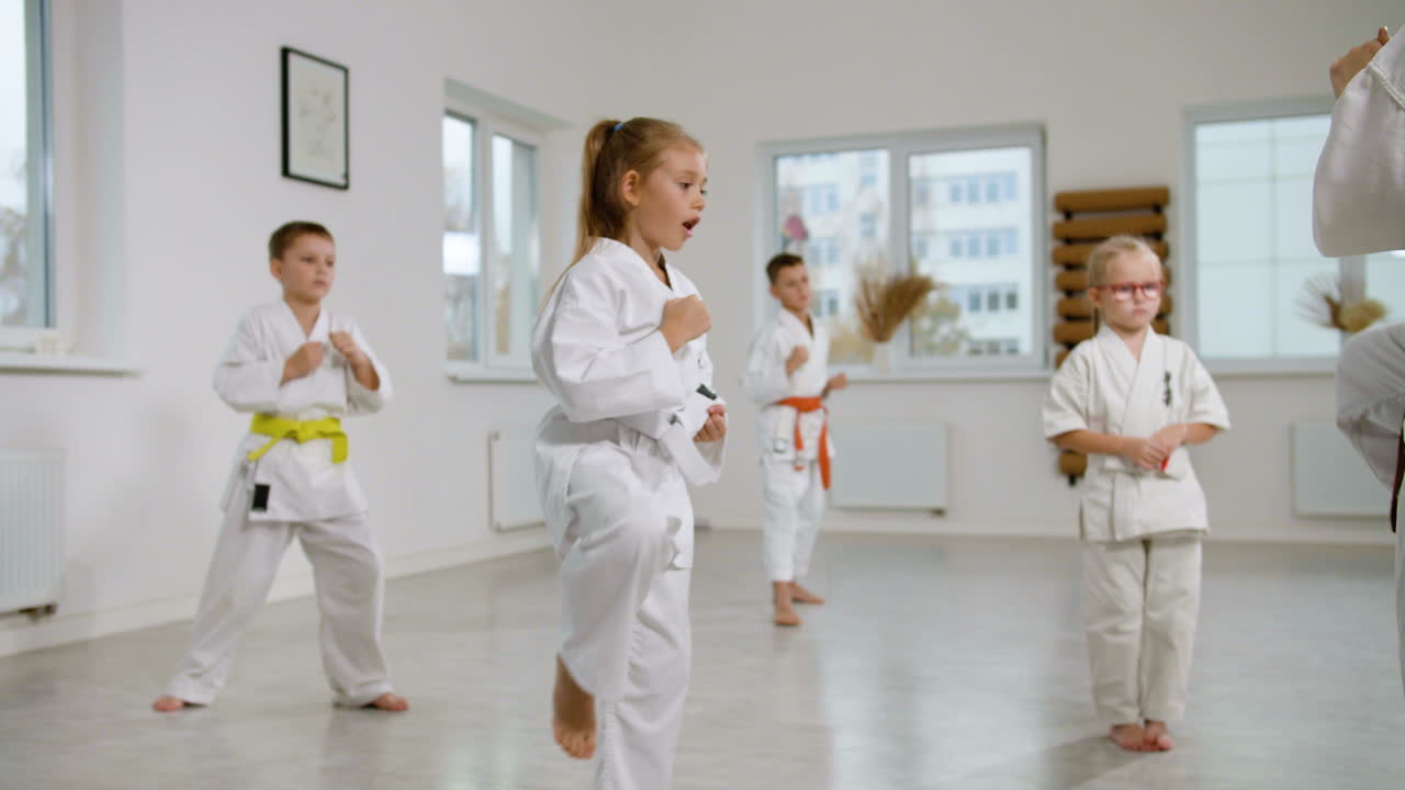 niña con kimono blanco en la clase de artes marciales
