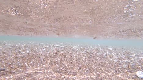 Underwater-view-of-small-waves-crashing-onto-a-white-sand-beach-on-Koh-Tao-Island-in-Thailand