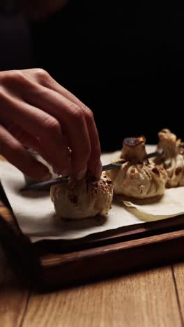 woman preparing or serving dumplings with sauce