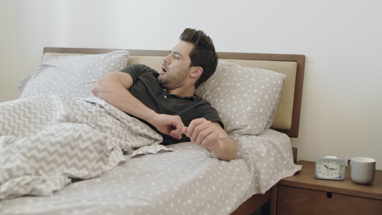 Premium stock video - Lethargic man waking up in morning slowly ...