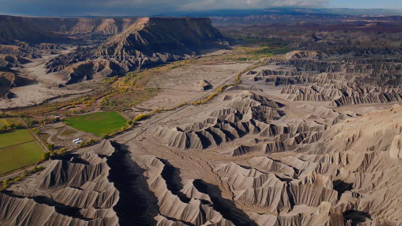 Lagdelte ørkenbadlands-åser og eroderte rygger som strekker seg over tørt terreng nær Factory Butte Utah, drone