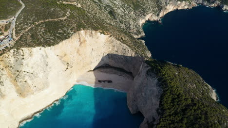 Toma-Cinematográfica-De-Drones-De-La-Playa-De-Navagio,-Playa-Del-Naufragio-Ubicada-En-La-Costa-Noroeste-De-Zakynthos.