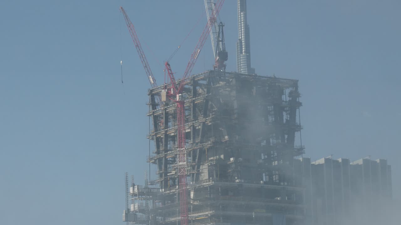 Shot of a huge skyscraper getting built in front of the highest building in the world the burj khalifa in dubai